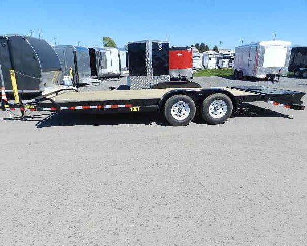 a Big Tex flatbed trailer is parked in a parking lot next to a row of trailers