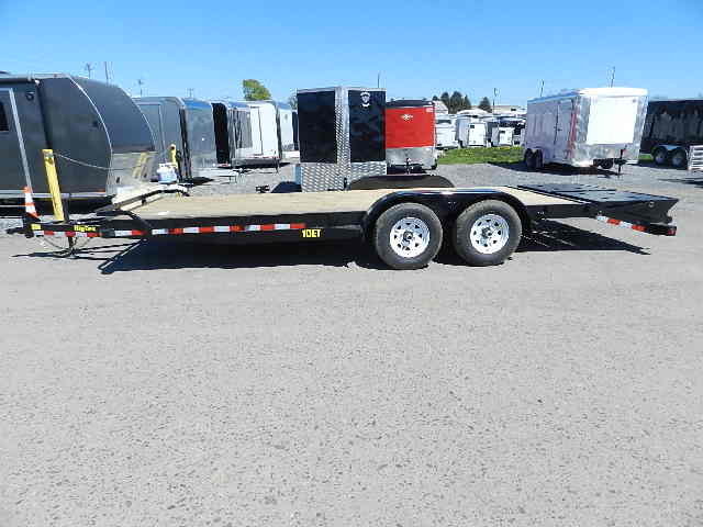 a Big Tex flatbed trailer is parked in a parking lot next to a row of trailers