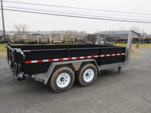 a dump trailer is parked on the side of the road .