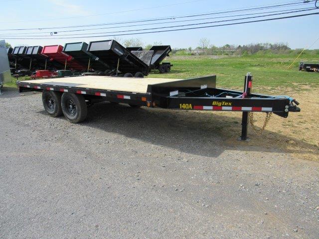 a flatbed trailer is parked on the side of the road .