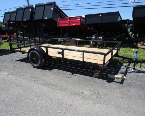 a Big Tex trailer with a wooden deck parked next to a row of dump trailers