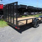 a small trailer is parked on the side of the road .