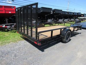 a small trailer is parked on the side of the road .