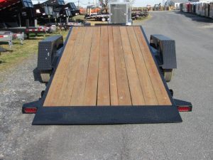 a Bwise trailer with a wooden deck parked on the side of the road