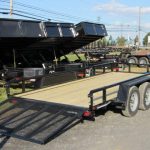 a cam trailer parked next to dump trailers