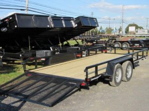 a cam trailer parked next to dump trailers
