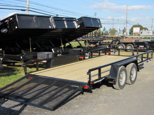 a cam trailer parked next to dump trailers