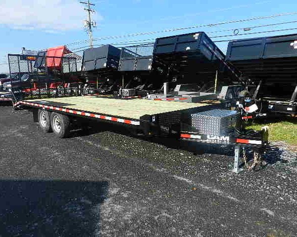 a flatbed trailer is parked on the side of the road .