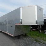 a silver Car Mate enclosed gooseneck trailer