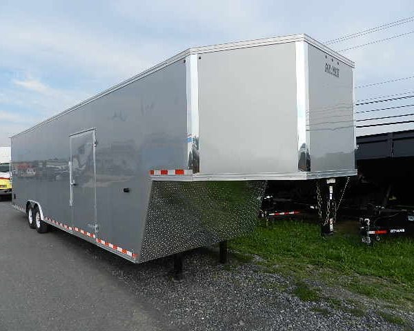 a silver Car Mate enclosed gooseneck trailer