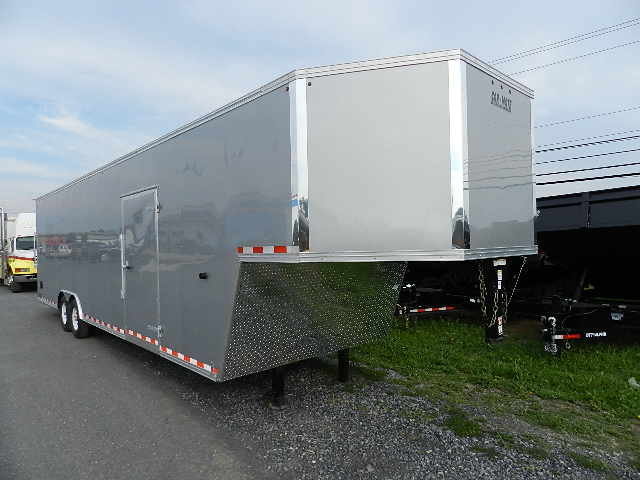 a silver Car Mate enclosed gooseneck trailer