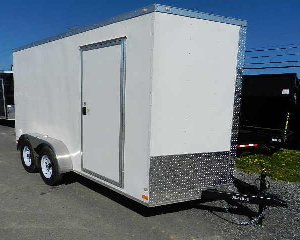 a white trailer is parked on the side of the road