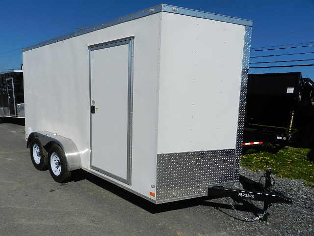 a white trailer is parked on the side of the road