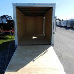 a Covered Wagon trailer with the door open parked on the side of the road