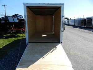 a Covered Wagon trailer with the door open parked on the side of the road