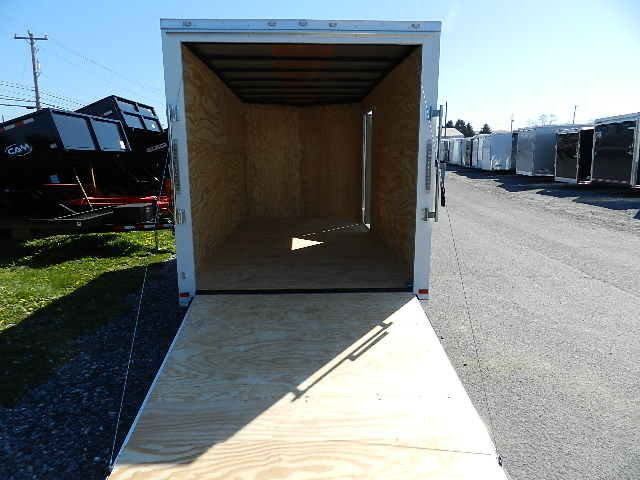 a Covered Wagon trailer with the door open parked on the side of the road