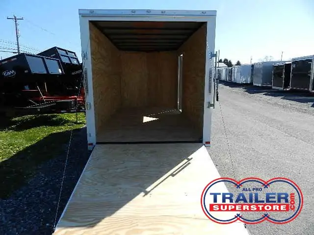 a Covered Wagon trailer with the door open parked on the side of the road