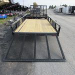 a trailer with a wooden deck is parked on the side of the road