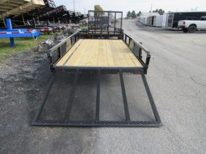 a trailer with a wooden deck is parked on the side of the road