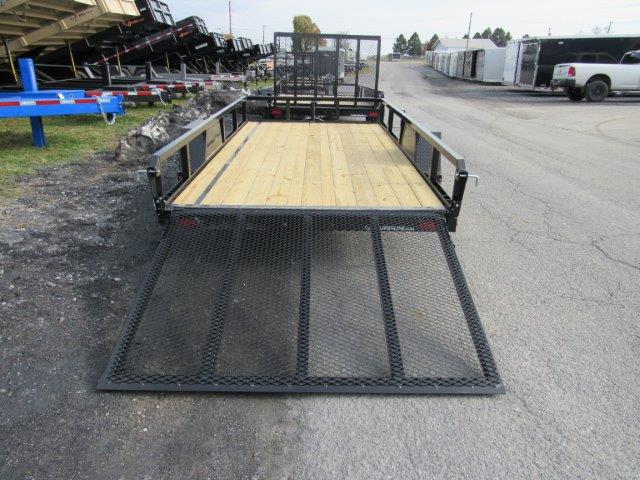 a trailer with a wooden deck is parked on the side of the road