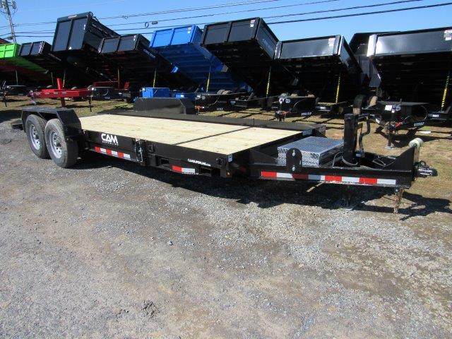 a CAM Superline trailer with a wooden deck parked next to a row of dump trailers