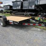 a cam trailer is parked next to a row of dump trailers