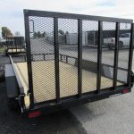a trailer with a mesh fence is parked on the side of the road