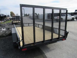 a trailer with a mesh fence is parked on the side of the road