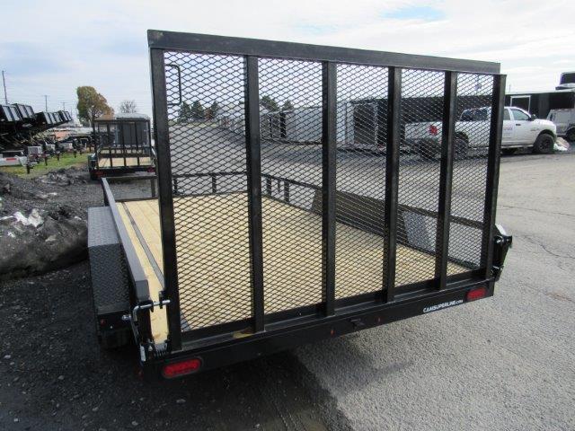 a trailer with a mesh fence is parked on the side of the road
