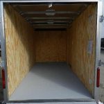 the inside of an empty trailer with the door open .