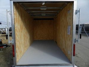 the inside of an empty trailer with the door open .