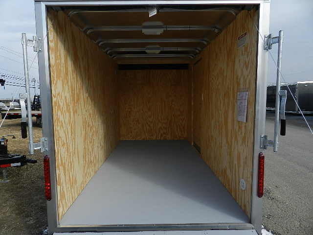 the inside of an empty trailer with the door open .