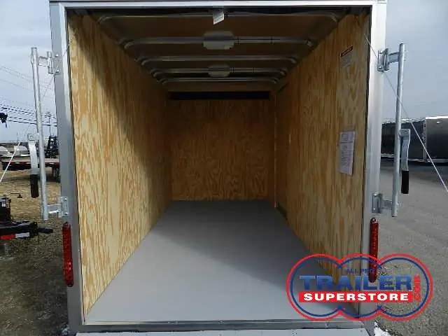 the inside of an empty trailer with the door open .