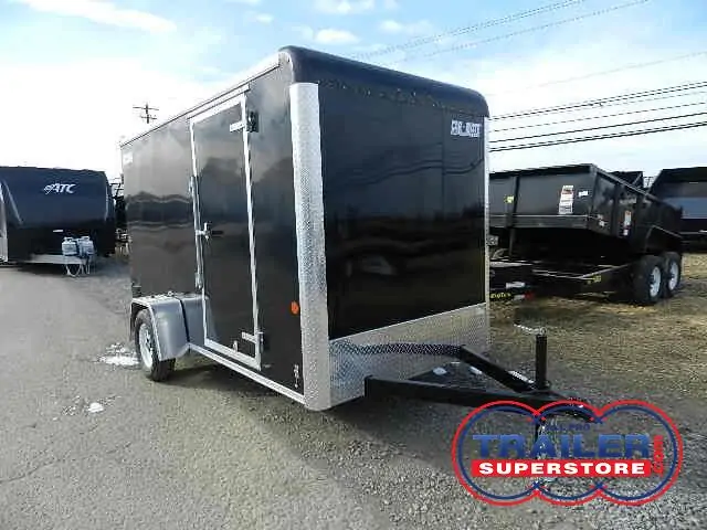 a black trailer is parked on the side of the road next to a dumpster .