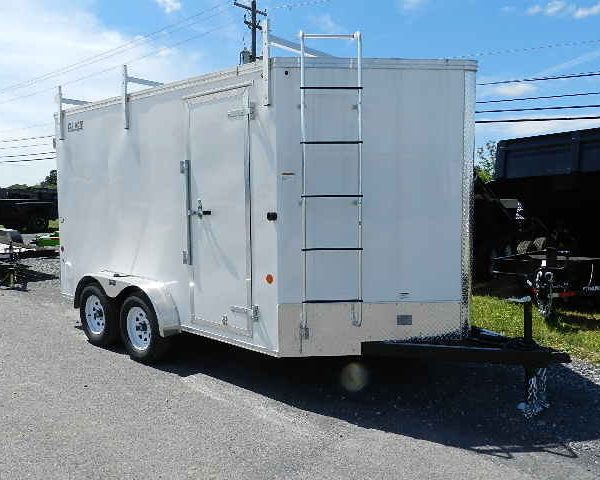a white trailer with a ladder attached to the side is parked on the side of the road