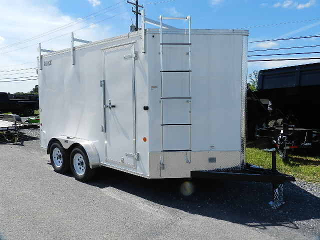 a white trailer with a ladder attached to the side is parked on the side of the road