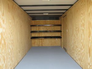 a very long empty room with wooden walls and shelves