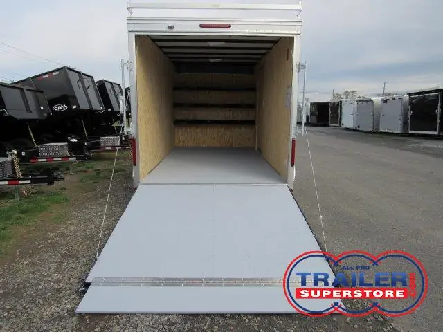 a white trailer with the door open is parked on the side of the road .