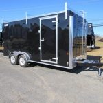 a black trailer parked on the side of the road