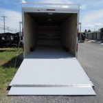 a white trailer is parked in a parking lot with the door open