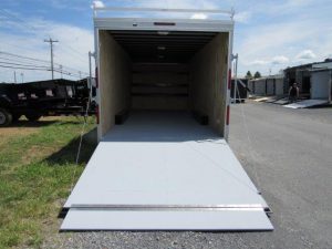 a white trailer is parked in a parking lot with the door open