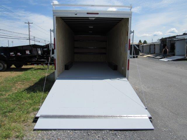 a white trailer is parked in a parking lot with the door open