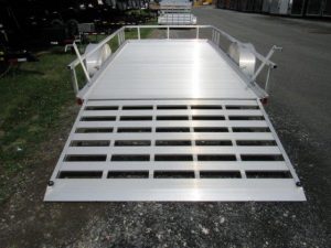a silver trailer is parked on the side of the road .