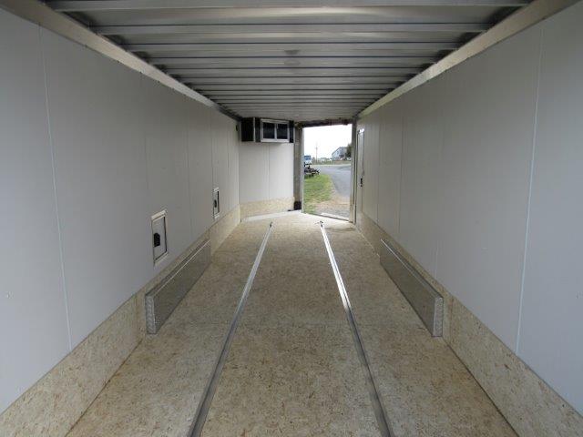 the inside of an empty trailer with the door open .