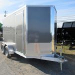 a gray and silver trailer parked on the side of the road
