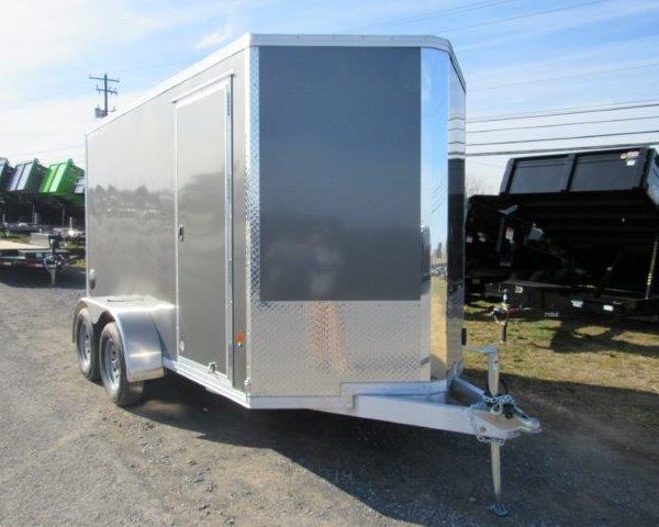 a gray and silver trailer parked on the side of the road