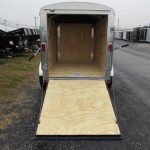 a trailer with the door open is parked on the side of the road .