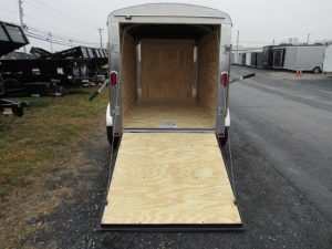 a trailer with the door open is parked on the side of the road .