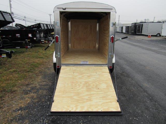 a trailer with the door open is parked on the side of the road .