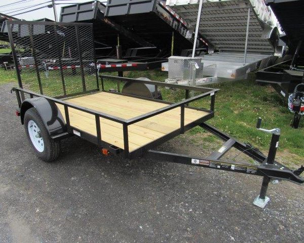 a small trailer with a wooden deck is parked on the side of the road .